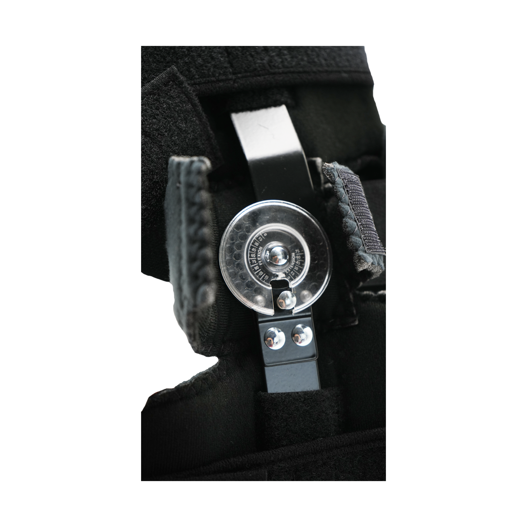 Close-up of adjustable black orthopedic elbow brace hinge with metal components and Velcro straps.