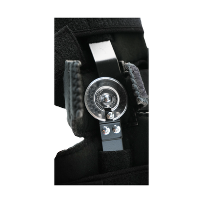 Close-up of adjustable black orthopedic elbow brace hinge with metal components and Velcro straps.