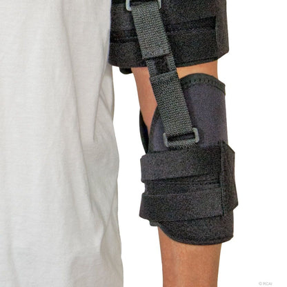 Black neoprene shoulder stabilizer with adjustable straps worn on left arm against white shirt background.
